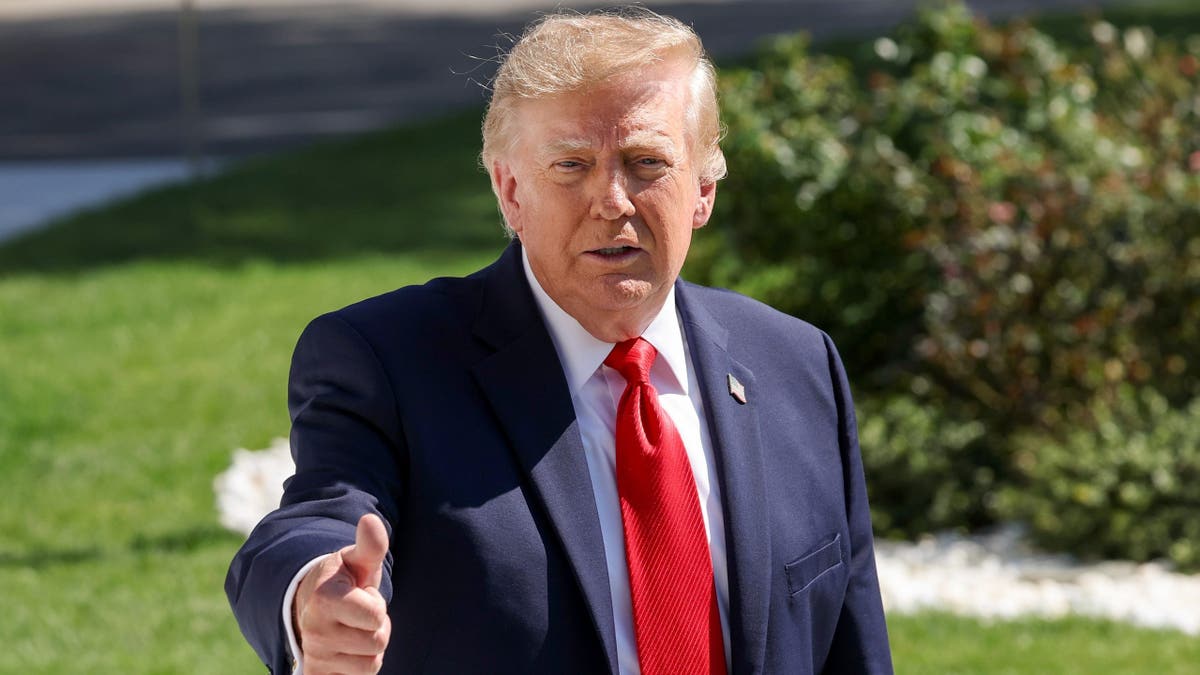 Trump gives a thumbs-up gesture.